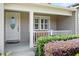 Close-up of a quaint front porch with white pillars, a cozy bench, and well-maintained landscaping at 3514 Golfview Blvd, Orlando, FL 32804