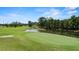 Scenic golf course view featuring a green, pond, and mature trees, offering a tranquil and picturesque setting at 3514 Golfview Blvd, Orlando, FL 32804