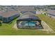 Aerial view shows the screened pool with spa surrounded by backyard, showcasing the neighborhood at 4307 Pebbles Throw Dr, Kissimmee, FL 34746