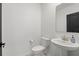 Minimalist half bathroom featuring a pedestal sink, toilet, and dark-trimmed mirror at 4307 Pebbles Throw Dr, Kissimmee, FL 34746