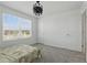 Bright bedroom features a large window, stylish light fixture, and neutral-toned walls and carpet at 4307 Pebbles Throw Dr, Kissimmee, FL 34746
