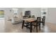 Open-concept dining area with a wooden table for six, flowing into the living area and backyard at 4307 Pebbles Throw Dr, Kissimmee, FL 34746