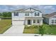 Beautiful two-story home with a large driveway, lush landscaping, and inviting entryway at 4307 Pebbles Throw Dr, Kissimmee, FL 34746