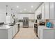 Bright white kitchen featuring stainless steel appliances, quartz countertops, and a kitchen island with a sink at 4307 Pebbles Throw Dr, Kissimmee, FL 34746