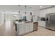 Open concept kitchen with a white island, stainless steel appliances and views of the living and dining areas at 4307 Pebbles Throw Dr, Kissimmee, FL 34746