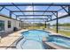 Relax in the screened pool with spa, featuring a beautiful view of the surrounding greenery and lake at 4307 Pebbles Throw Dr, Kissimmee, FL 34746