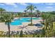 A beautiful community pool boasts ample seating and palm tree accents at 4307 Pebbles Throw Dr, Kissimmee, FL 34746