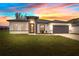 Beautiful single-story home featuring lush green lawn, gray two-car garage, and modern architecture with a picturesque sunset background at 4450 Sw 169Th Pl, Ocala, FL 34473