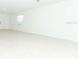 Bright open-concept living room with light colored tile flooring, neutral walls, and window at 4787 Guinep Ln, Kissimmee, FL 34758