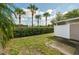 View of the backyard with green grass, privacy fence and hedge, and lovely mature palm trees at 5004 Ashford Falls Ln, Oviedo, FL 32765