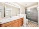 Bathroom featuring a wood vanity, large mirror, and tiled walk-in shower with glass door at 5004 Ashford Falls Ln, Oviedo, FL 32765