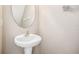 Powder room with pedestal sink, oval mirror, and neutral paint, ideal for guests at 5004 Ashford Falls Ln, Oviedo, FL 32765