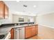 Spacious kitchen featuring stainless steel dishwasher, wood cabinets, and breakfast bar overlooking the living room at 5004 Ashford Falls Ln, Oviedo, FL 32765