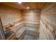 Relaxing sauna room with wooden benches and a traditional sauna bucket and heater at 5300 S Atlantic Ave # 4-302, New Smyrna Beach, FL 32169