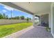 An outdoor back patio with brick pavers, leading to a well-maintained backyard with green grass and a fence at 5660 Oak Knoll Dr, St Cloud, FL 34771