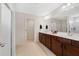 Bathroom featuring double vanity, tile floors, walk-in shower, and large mirror at 5660 Oak Knoll Dr, St Cloud, FL 34771
