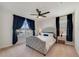 Bedroom with neutral carpet, ceiling fan, window with dark curtains, bed, and night stands at 5660 Oak Knoll Dr, St Cloud, FL 34771
