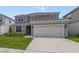 Charming two-story home boasts a manicured lawn and a convenient two-car garage at 5660 Oak Knoll Dr, St Cloud, FL 34771