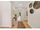 Hallway with hardwood floors, neutral paint, decorative mirrors, and view to backyard at 5660 Oak Knoll Dr, St Cloud, FL 34771