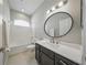 Bathroom with an extended vanity, oval mirror, and shower-tub combo at 5829 Valentino Way, Lakeland, FL 33812
