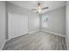 Bright bedroom with gray walls, wood-look flooring, ceiling fan and a double door closet at 5829 Valentino Way, Lakeland, FL 33812