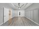 Spacious bedroom featuring modern gray walls, a ceiling fan, and light wood flooring at 5829 Valentino Way, Lakeland, FL 33812