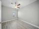 Comfortable bedroom with wood-look floors, ceiling fan, and a window with natural light at 5829 Valentino Way, Lakeland, FL 33812