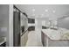 Modern kitchen featuring stainless steel appliances, dark cabinets, and a large island with marble countertops at 5829 Valentino Way, Lakeland, FL 33812