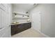 Functional laundry room featuring plenty of counter space, cabinetry, and floating shelves for storage at 5829 Valentino Way, Lakeland, FL 33812