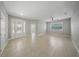 Spacious living room featuring tile floors, a ceiling fan, and ample natural light from large windows at 5829 Valentino Way, Lakeland, FL 33812