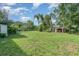 Large backyard with mature trees, lush green lawn, and detached garage at 605 Ensenada Dr, Orlando, FL 32825