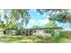 Charming single-story home with a well-maintained lawn, mature trees, and inviting front entrance at 605 Ensenada Dr, Orlando, FL 32825
