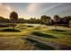 Beautiful golf course landscape featuring rolling hills, palm trees, a walking path, and a serene lake at 605 Ensenada Dr, Orlando, FL 32825