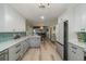 Open-concept kitchen with white cabinets, stainless appliances, and modern finishes at 605 Ensenada Dr, Orlando, FL 32825