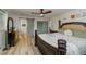 This spacious main bedroom features a four-post bed, wood-look flooring, a ceiling fan, and an ensuite bathroom with barn door at 605 Ensenada Dr, Orlando, FL 32825