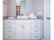 Modern bathroom with granite countertop, vessel sink, white cabinetry, and a large mirror reflecting the shower at 7595 Sunny Dreams Ln, Kissimmee, FL 34747