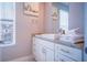 Well-lit bathroom features a granite countertop with modern fixtures, white cabinets, and a large mirror at 7595 Sunny Dreams Ln, Kissimmee, FL 34747