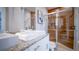 Modern bathroom featuring double sinks, granite countertops, and a stylish glass-enclosed shower with wood-look tile at 7595 Sunny Dreams Ln, Kissimmee, FL 34747