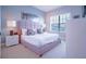 Comfortable bedroom with a padded headboard, two bedside tables, and a window with blinds at 7595 Sunny Dreams Ln, Kissimmee, FL 34747