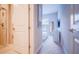 Hallway leading to bedroom featuring an ensuite bathroom and neutral decor at 7595 Sunny Dreams Ln, Kissimmee, FL 34747