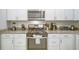 Modern kitchen featuring a gas range, granite countertops, and stainless-steel appliances at 7595 Sunny Dreams Ln, Kissimmee, FL 34747