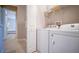Convenient laundry room with modern appliances and built-in shelving for efficient storage and organization at 7595 Sunny Dreams Ln, Kissimmee, FL 34747