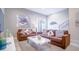Comfortable living room featuring a brown sofa set, bright decor, and a walkout to the backyard at 7595 Sunny Dreams Ln, Kissimmee, FL 34747