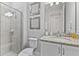 Bathroom featuring a step-in shower with tile surround and glass door, a white vanity and gray walls at 7759 Westland Dr, Kissimmee, FL 34747