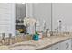 Bathroom features double sinks with granite countertops, decorative orchids, and modern fixtures at 7759 Westland Dr, Kissimmee, FL 34747