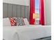 Comfortable bedroom with a gray headboard, bright red curtains, and a chic bedside lamp at 7759 Westland Dr, Kissimmee, FL 34747