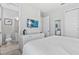 This bedroom features a white bed with white bedding, a wall mounted TV, and an adjacent bathroom at 7759 Westland Dr, Kissimmee, FL 34747