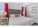 Bright bedroom with a gray headboard, crisp white linens, and vibrant red curtains at 7759 Westland Dr, Kissimmee, FL 34747