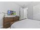 Bedroom with bed, dresser, mounted TV, and white doors, creating a calm and inviting space at 7759 Westland Dr, Kissimmee, FL 34747