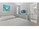 This bedroom features two twin beds, a wall art and a dresser with an adjacent bathroom at 7759 Westland Dr, Kissimmee, FL 34747